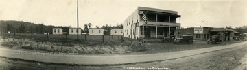 Oversize postcard of cabins, camp main office and a gas station