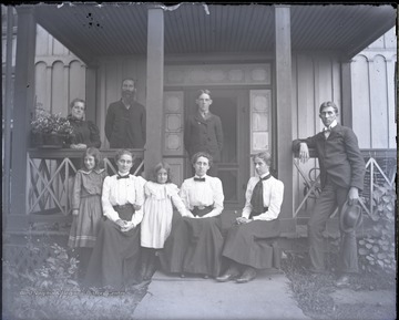 Family portrait taken outside on a front porch. All persons are not identified.