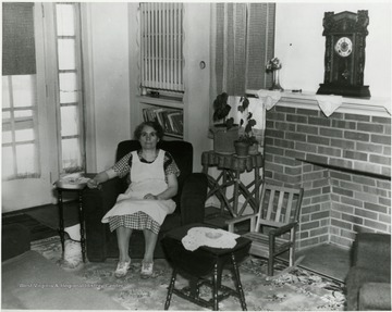 Unidentified woman relaxes in a home built during the Homestead Project in Preston County.