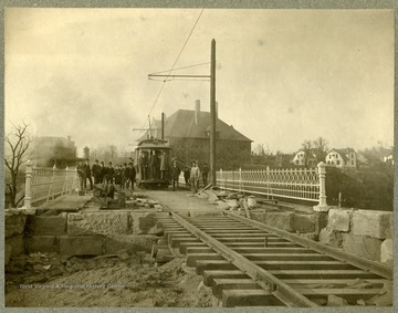 Several unidentified men pose on the newly constructed bridge, contracted for $18,632. The bridge was 467 feet long and designed to support a 24 ton street car. 