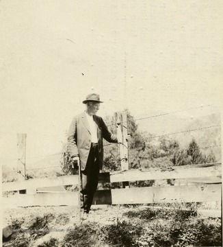 Information included with the photograph,"Hu Maxwell standing where Polly Stephenson's cabin was. All that remains of the cabin is a heap of stones which had been the chimney."