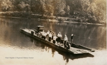 The ferry transports unidentified people and an automobile, possible a Model T, across the river.