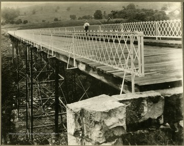 The bridge crosses Deckers Creek into the Greenmont area. The man standing on the bridge is not identified.
