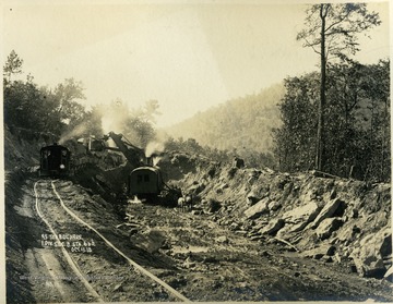 A bugyrus moves earth into rail cars to be towed away in the western Maryland mountains.