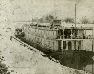 Captain Ellsworth Eisenbarth's showboat traveled the Ohio River, advertised as "The Modern Temple of Amusement". Here the steamboat is towed through icy waters by the "Lula F.", built at Palestine, West Virginia in 1890.