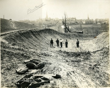 Several unidentified workers stand in the railroad cut. The town of Frostburg, Allegany County, Maryland is in the background.