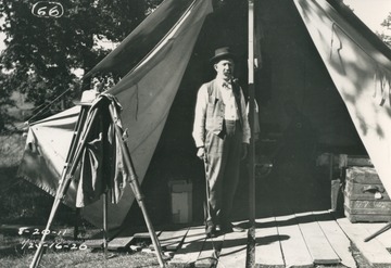 Member of survey expedition team hired to mark north-south boundary of West Virginia and Maryland stands outside of one of their tents in camp.