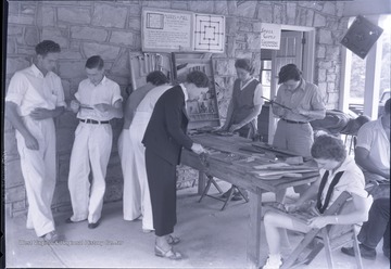Camp volunteer workers examine various games and equipment.