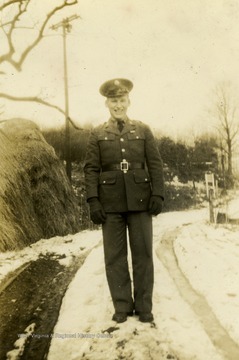 Foley poses outside on a snow covered road wearing an uniform.
