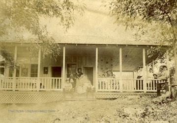 Members of the Miller family pose on the front porch, none are identified.