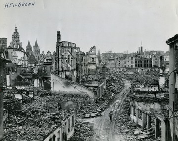 Information with the photograph, "A lone soldier of the 100th Infantry Division, Seventh U.S. Army, walks through the ruins of Heilbronn, Germany, cleared of the enemy April 12, 1945. Forty miles southeast of Mannheim and the Rhino, Heilbronn, an important road and rail center was blasted by Allied Planes. U.S. Signal Corps Photo."