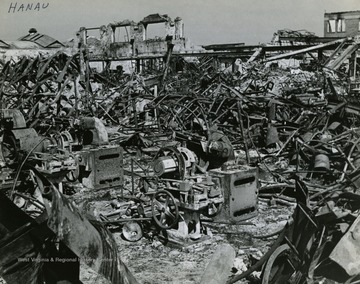 Information included with the photograph,"Overall view showing the damage done by the RAF and the U.S. Eighth Air Force to the Deutsche Dunlop A.G. Tire and rubber factory at Hanau. The widespread destruction in this plant severely cut part of the German tire production for motor vehicles. This part of the plant ceased to produce after the last air attack that left it the mass of twisted girders and rubble shown." See the back of the original photograph for more information.