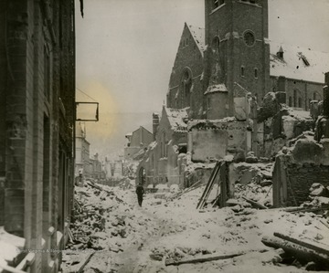 Information on back of picture reads: "A civilian picks his way through the rubble littering the streets of Laroche, Belgium, formerly an important enemy communications center on the northern flank of the Ardonnes Salient. Supreme Headquarters Allied Expeditionary Force announced January 12, 1945, that Allied troops had taken the Belgian town. Only a little over a month after the launching of the unsuccessful Nazi counter-thrust December 16, 1944, front lone correspondents made it clear by midnight January 22, 1945, that the Battle of the Ardonnes was practically over."