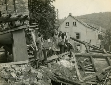 Information on back of photo reads: "German civilians look over the ruins of their home which was shelled by American troops in the attack on Weifall, Germany."