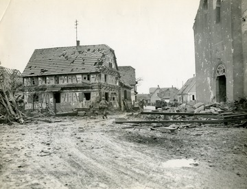 Caption on back of photo reads: "American infantrymen of 36th Division run through rubble littered street of battle-scarred Rohrwiller, France. Town is under enemy attack."