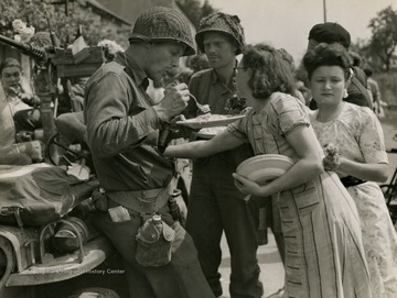 Information on back of photo reads: "Capt. Philip Staples; Ardmore, Pennsylvania enjoys a fresh made egg omelette that was presented to him by grateful French civilians who had just been liberated from German hands, near Champagne."