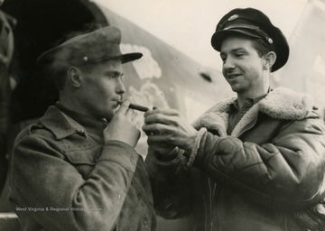 Information on back of photo reads: "American Sergeant Vivian L. Rees of Wingfield, Iowa, lights the cigar of Soviet Lieutenant Sergi Biernikov during the visit Red Army Day February 25, 1945, to liberated Soviet prisoners of war by U.S. Army Air Forces personnel who had served in the U.S.S.R. The American airmen collected tobacco and candy at their base in England as a gift to the Russians, also stationed in the British Isles."