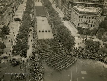 Information on back of photo reads: "Parisians line the Champs Elysees to cheer the massed infantry units of the American Army as they march in review towards the Arc De Triomphe, celebrating the liberation of the capital of France from Nazi occupation."