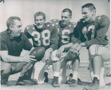 Caption on photo reads: "Miami, Florida, Dec. 20- Notre Dame All Stars- Coach Art Lewis of University of West Virginia, left, talks things over with this trio from Notre Dame who will play North College All Stars in the Orange Bowl Dec. 26. Left to right: Lewis, Pat Bisceglia, G; Gene Kapish, E; Dick Fitzgerald, FB."
