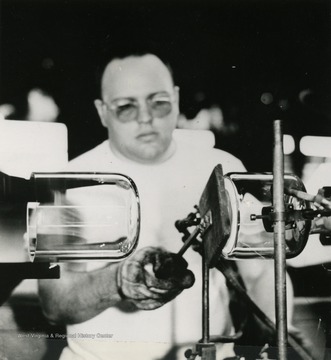 Caption on photo reads: "An employee at the Parkersburg, West Virginia plant of Corning Glass Works fabricates a fitting for Pyrex brand glass piping."