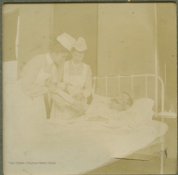 Unidentified nurses tend to a patient's bandaged arm.