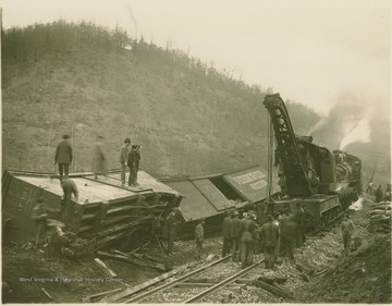A crane is used to clear away the wreckage from a train accident.