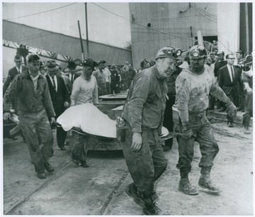 Caption reads: "Body removed from mine - Rescue miners carry a body from the Clinchfield Coal Co.'s Compass No. 2 Mine near Clarksburg, W. Va. after an explosion trapped 22 miners in the mine."
