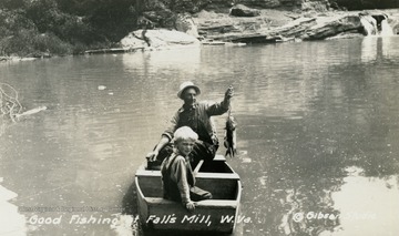 Man and young boy out fishing on Fall's Mill. Man is holding a couple of catfish on a line. (From postcard collection legacy system.)