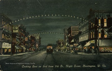 Trolley travels down the middle of the lighted street at night. Published by J.G. McCrorey &amp; Company. (From postcard collection legacy system.)