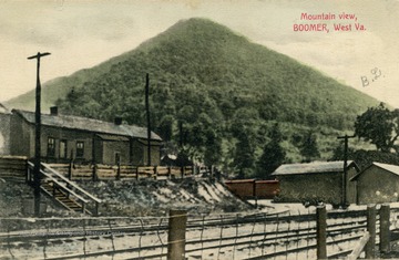 A mountain towers over a small train station. Published by Boomer Supple Company. (From postcard collection legacy system.)