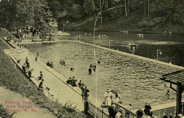 People can be seen hanging out in and around the pool as well as on the lake in canoes. Sign next to pool reads: "Use of tobacco and profanity strictly forbidden". See original for correspondence. (From postcard collection legacy system.)