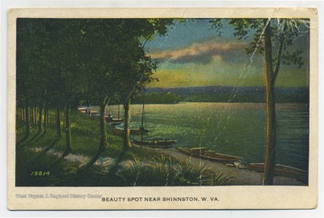A series of small boats line the river bank as the sun sets, creating a beautiful scenic view of the river. (From postcard collection legacy system.)