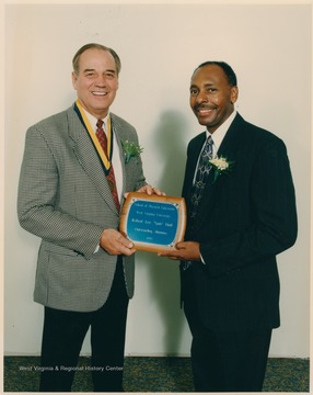 Dean Brooks presents Sam Huff with the School of Physical Education's "Outstanding Alumnus" award. Huff was an All-American football player for the Mountaineers from 1952-1955