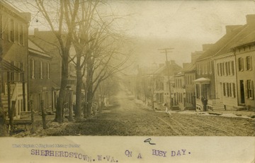 Dirt-paved main street looks desserted on this "busy day".(From postcard collection legacy system.)