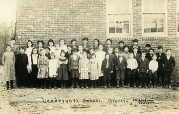 Vandervort School children and teacher Hiram Evans pose for picture outside of school building. (From postcard collection legacy system.)