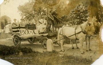 Group of women and children riding in horse drawn cart. Possibly on Memorial Day. (From postcard collection legacy system.)