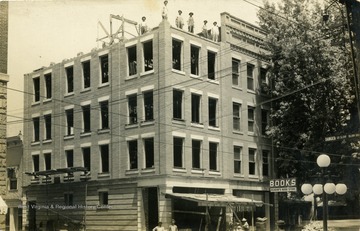 Construction workers stand atop the Brown Building. (From postcard collection legacy system.)