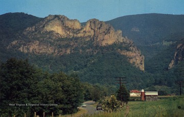 Caption on back of postcard reads:"One of the beauty spots in this area, this towering mass of quartzite was celebrated in Indian legend." Published by Neale's Drug Store Incorporated. (From postcard collection legacy system.)