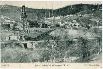Several oil derricks can be seen through out the small town. Image published by E. F. Millan.