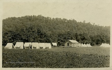 Lone soldier stands guard outside of tents. (From postcard collection legacy system--subject.)