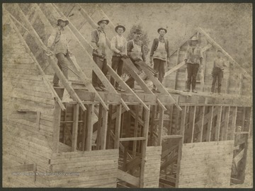 Men constructing what appears to be a house.