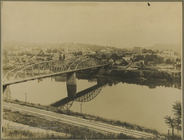 Photo of a bridge over the river connecting into town.