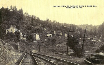 View from railroad tracks of homes on side of hill.