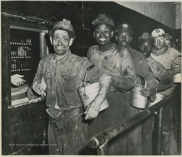 Photo description reads,"Vacation pay-- These miners, shown at paymaster's window at Osage Mine of Consolidation Coal Co., today started 10-day vac ation one day after union and operators reached contract agreement. They are picture as they lined up for $100 vacation pay."