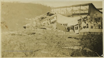 Photo showing destruction of building with its windows shattered and roof caving in. 