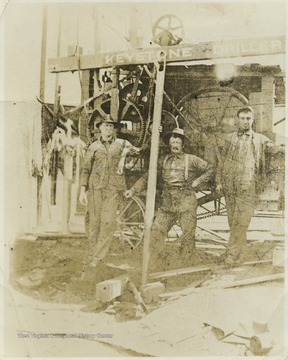 Three unidentified men pose by the drilling machine located in Monongalia County.
