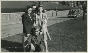 Back of the photo reads, "Mary Ethel, Phyllis, Ruth, and Francis". Francis kneels in his R.O.T.C. uniform while the girls gather around him. 