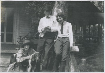 Older man and two young girls dog take photo in front of the home with their dog on Rockley Road in Morgantown, W. Va. Back of the photo reads, "Lucy (Daughter), Mrs. John L. Johnston, Anna L. (Daughter), Mrs. James P. Fitch, and Charles Johnson (Son)."