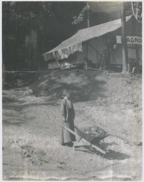 A girl stands by an overfilled wheelbarrow at the camp grounds located across from Quarry Run. 
