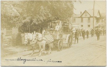 A horse-drawn carriage leads the men through the city street.